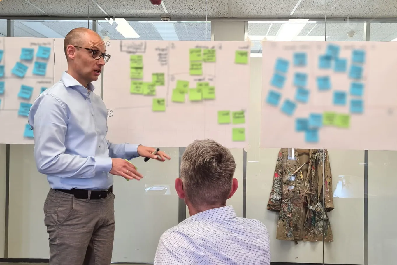 Michiel Kox in een sessie met een team, bij een wand vol post-its