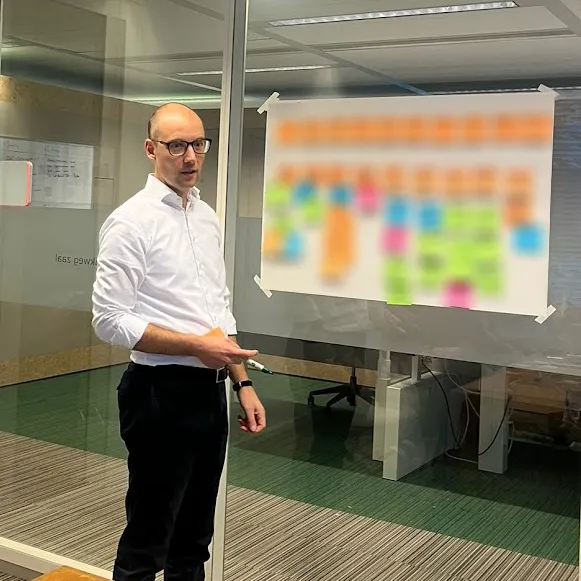 Michiel Kox bij een wand met post-its tijdens een sessie