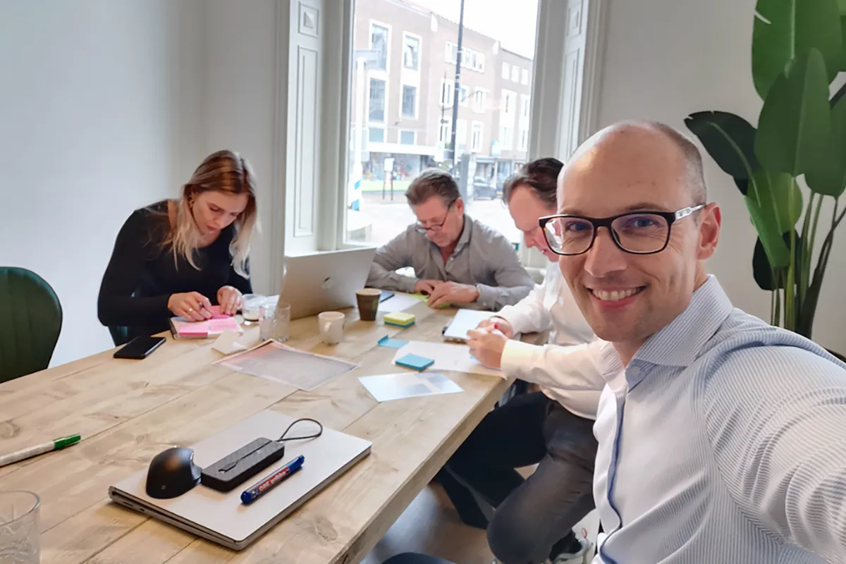 Michiel Kox aan tafel met het team van Plugz